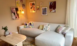 Een gezellige woonkamer met een lichte hoekbank, een salontafel en een inspirerende gallery wall maken.