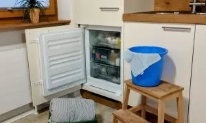 Vriezer niet goed dicht gedaan, met een blauwe emmer en doek klaar voor de ontdooiing.
