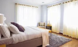 Een fris opgemaakt bed in een lichte slaapkamer. Vraag je je af hoe lang moet een bed luchten? Dit bed is klaar voor een frisse start.