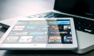 Tablet met filmscherm naast laptop. Een digitale collectie films, een moderne manier om cd's weggooien of bewaren te vermijden.