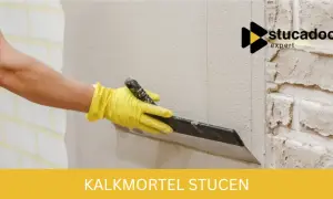 Hand met gele handschoen brengt kalkmortel aan op een binnenmuur met een troffel. Stucadoor expert.
