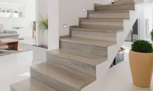 Moderne trap met houten look bekleding, perfect voor trap bekleden ideeen. Sfeervolle verlichting en planten maken het geheel af.