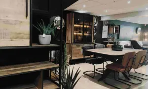 Een sfeervolle woonkamer met een **donker hout keuken** element, een eettafel met stoelen en planten.