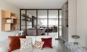 Moderne woonkamer met glazen wand, houten wandrek en comfortabele bank. Een nis in de muur is stijlvol ingericht.