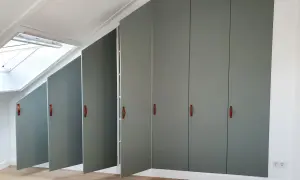 Moderne grijze kasten met leren handgrepen, perfect voor de achterkant kast afwerken. Een dakraam zorgt voor natuurlijk licht.