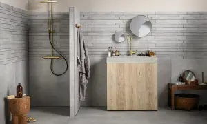Grijze badkamer met houten meubel. Welke kleur handdoeken passen hierbij? Een grijze handdoek hangt aan de muur.