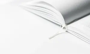 Een open boek met een wit lint, dat de essentie van minimalisme uitstraalt.