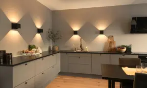 Moderne keuken met sfeervolle keuken verlichting inspiratie. Zwarte wandlampen creëren een prachtig lichtspel op de grijze muur.