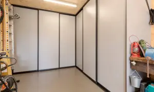 Een moderne kast in de garage, ideaal om spullen op te bergen. Fietsen en gereedschap staan netjes opgesteld.