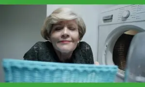 Vrouw geniet van de geur van lekker ruikende was uit de droger.
