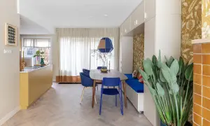 Een moderne eetkamer met een gele keuken en blauwe stoelen. De RAL 7006 combineren met de blauwe en gele accenten zorgt voor een levendige sfeer.