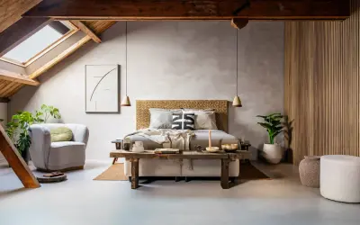 Slaapkamer met een bed, fauteuil, planten en een rustieke houten bank. De **plattegrond slaapkamer** toont een sfeervolle, lichte ruimte met een schuin dak.