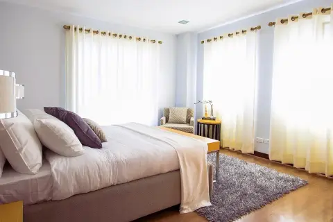 Een fris opgemaakt bed in een lichte slaapkamer. Vraag je je af hoe lang moet een bed luchten? Dit bed is klaar voor een frisse start.