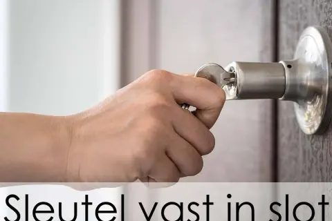 Hand probeert een sleutel in een deurklink te draaien, maar de sleutel zit vast in het slot en draait niet.