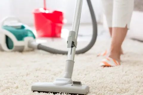 Een stofzuiger op een wit tapijt, klaar om de ruimte schoon te maken en de stofzuiger lekker te laten ruiken.