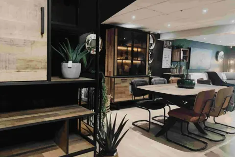 Een sfeervolle woonkamer met een **donker hout keuken** element, een eettafel met stoelen en planten.
