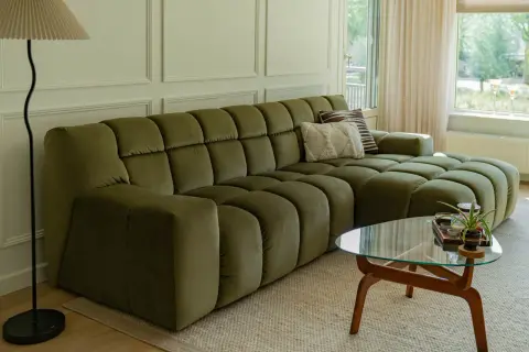 Een olijfgroene bank met zachte kussens, de perfecte basis. Welke kleur past bij groene bank? Denk aan warme aardetinten of frisse pastels voor een harmonieus interieur.