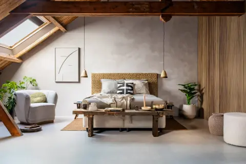 Slaapkamer met een bed, fauteuil, planten en een rustieke houten bank. De **plattegrond slaapkamer** toont een sfeervolle, lichte ruimte met een schuin dak.