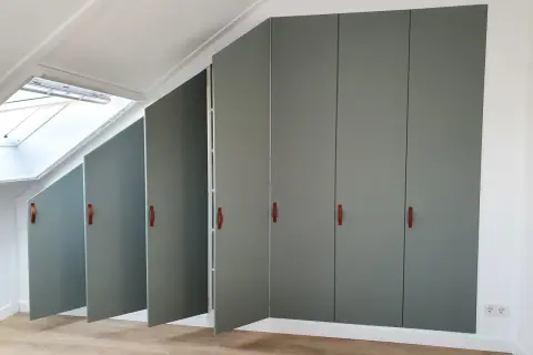 Moderne grijze kasten met leren handgrepen, perfect voor de achterkant kast afwerken. Een dakraam zorgt voor natuurlijk licht.