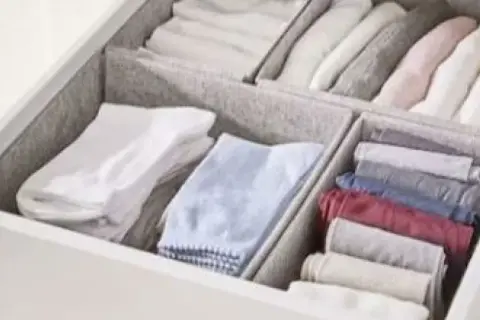 Een opgeruimde lade met netjes gevouwen kleding, geïnspireerd door de Marie Kondo methode. Kledingkast organizers houden alles netjes.
