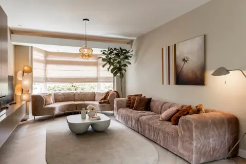 Een ruime, lichte woonkamer met comfortabele, roze banken en een bijzettafel. Dit is wat een vestibule kan zijn: een uitnodigende entree tot ontspanning.
