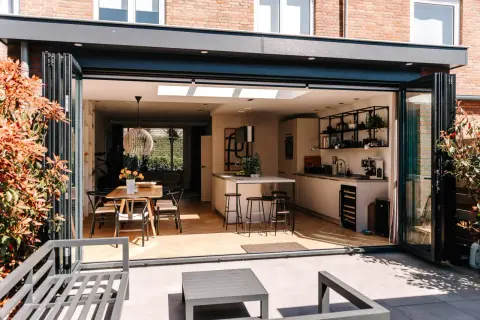 Moderne keuken en eethoek in een vergunningsvrij uitgebouwde achterzijde woning, met vouwdeuren naar terras.