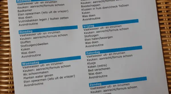 Een huishoudschema met taken per dag, zoals vaatwasser inruimen, keuken schoonmaken en was doen.