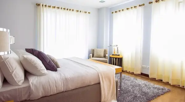 Een fris opgemaakt bed in een lichte slaapkamer. Vraag je je af hoe lang moet een bed luchten? Dit bed is klaar voor een frisse start.