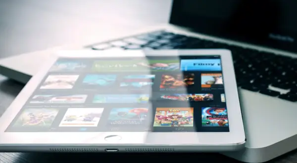 Tablet met filmscherm naast laptop. Een digitale collectie films, een moderne manier om cd's weggooien of bewaren te vermijden.