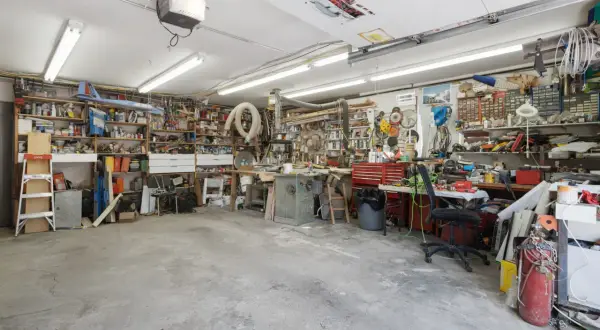 Een georganiseerde garage met motor, fietswielen, helmen, ballen en posters. Inspirerende garage ideeen voor elke hobbyist.