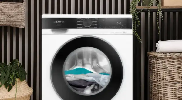 De wasmachine trommel loopt aan met een lading kleding, klaar voor een frisse wasbeurt.