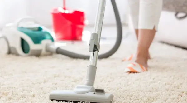 Een stofzuiger op een wit tapijt, klaar om de ruimte schoon te maken en de stofzuiger lekker te laten ruiken.