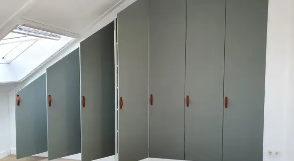 Moderne grijze kasten met leren handgrepen, perfect voor de achterkant kast afwerken. Een dakraam zorgt voor natuurlijk licht.