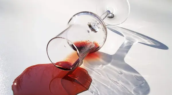 Om een opgedroogde rode wijnvlek te verwijderen, zoals tante Kaat ons leerde, is dit de situatie: een omgevallen glas rode wijn op een witte ondergrond.