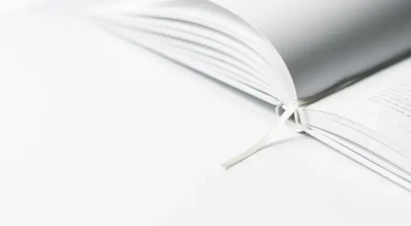 Een open boek met een wit lint, dat de essentie van minimalisme uitstraalt.