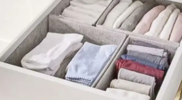 Een opgeruimde lade met netjes gevouwen kleding, geïnspireerd door de Marie Kondo methode. Kledingkast organizers houden alles netjes.