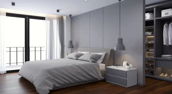 Moderne slaapkamer met een groot bed, nachtkastje en een open inloopkast. De plattegrond van deze slaapkamer met inloopkast is stijlvol en opgeruimd.
