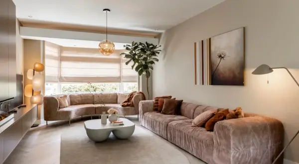 Een ruime, lichte woonkamer met comfortabele, roze banken en een bijzettafel. Dit is wat een vestibule kan zijn: een uitnodigende entree tot ontspanning.