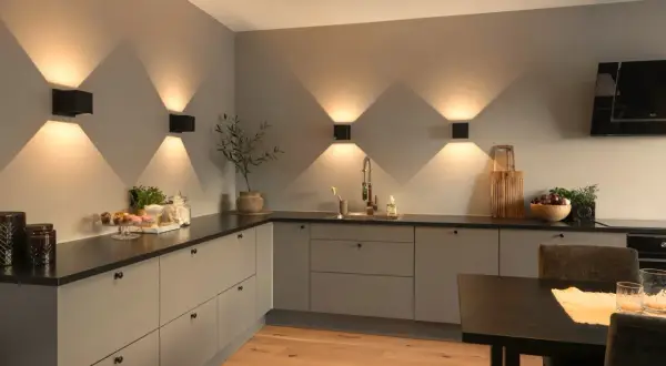 Moderne keuken met sfeervolle keuken verlichting inspiratie. Zwarte wandlampen creëren een prachtig lichtspel op de grijze muur.