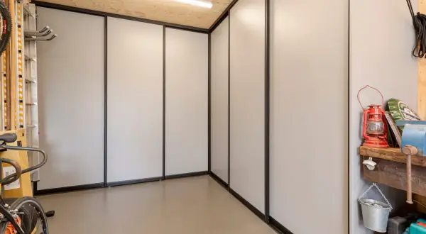 Een moderne kast in de garage, ideaal om spullen op te bergen. Fietsen en gereedschap staan netjes opgesteld.