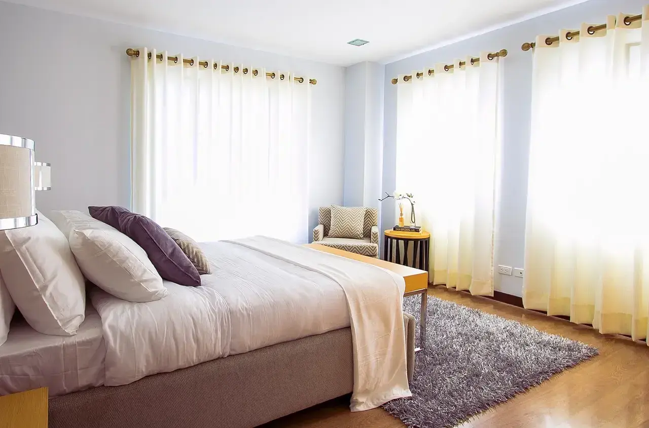 Een fris opgemaakt bed in een lichte slaapkamer. Vraag je je af hoe lang moet een bed luchten? Dit bed is klaar voor een frisse start.