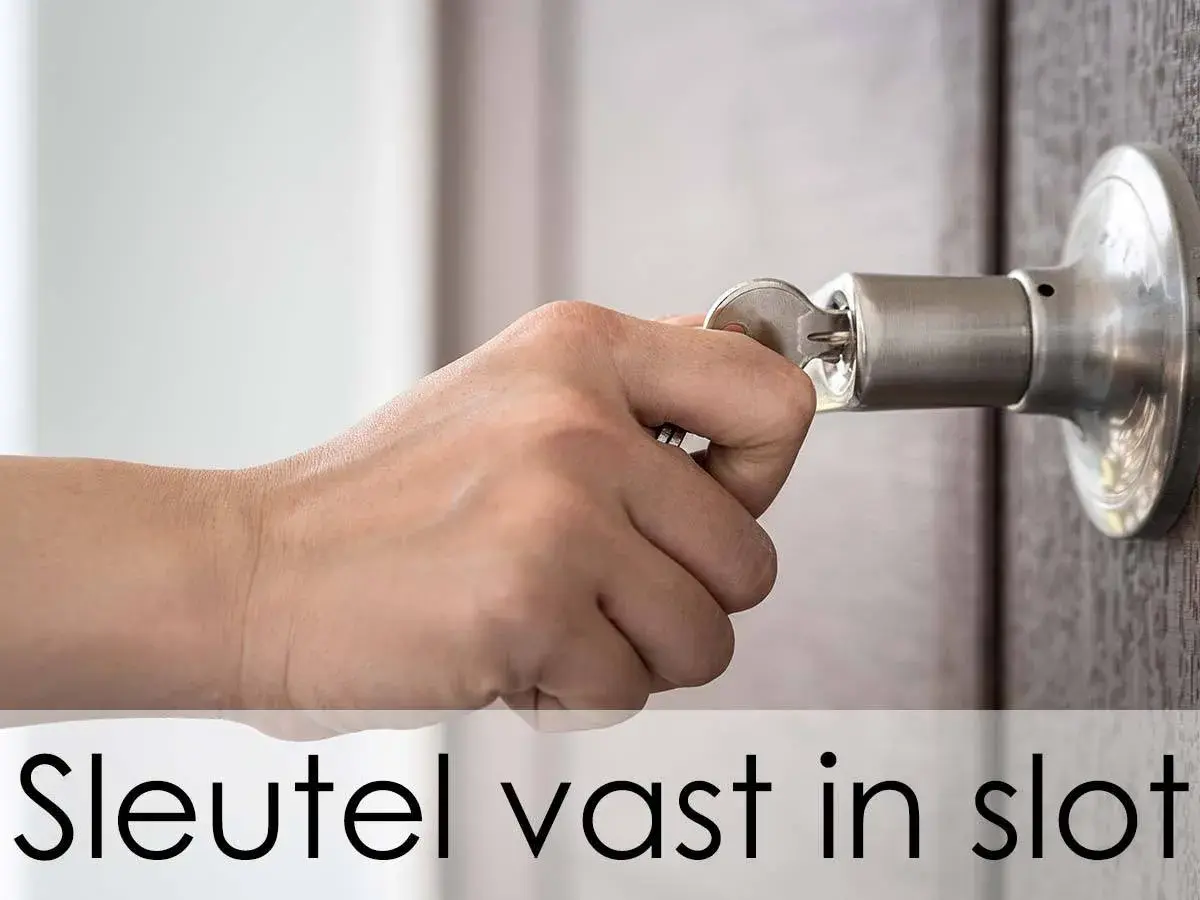 Hand probeert een sleutel in een deurklink te draaien, maar de sleutel zit vast in het slot en draait niet.