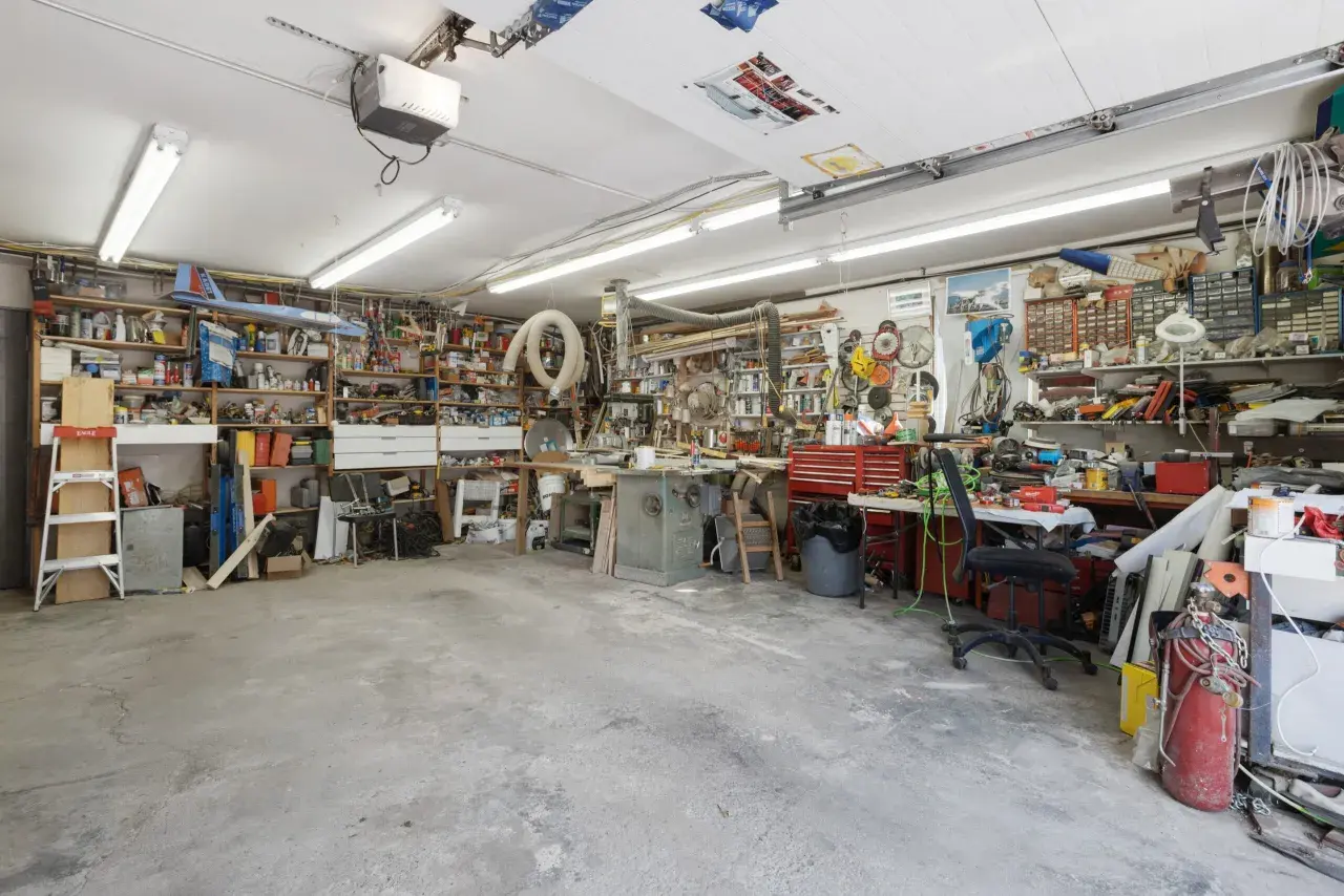 Een georganiseerde garage met motor, fietswielen, helmen, ballen en posters. Inspirerende garage ideeen voor elke hobbyist.