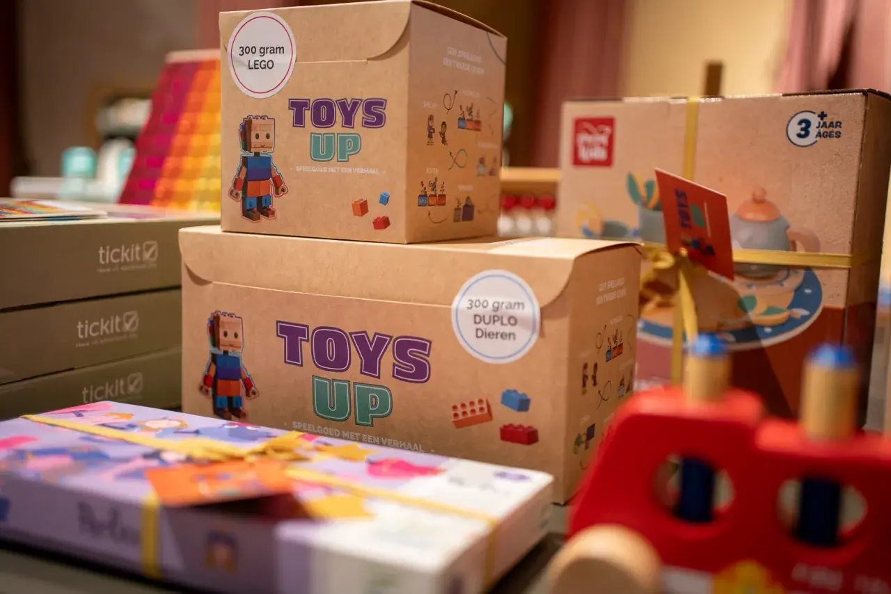 Dozen met LEGO en DUPLO speelgoed, klaar om tweedehands spullen te doneren. Elk doosje "Toys Up" geeft speelgoed een tweede leven.