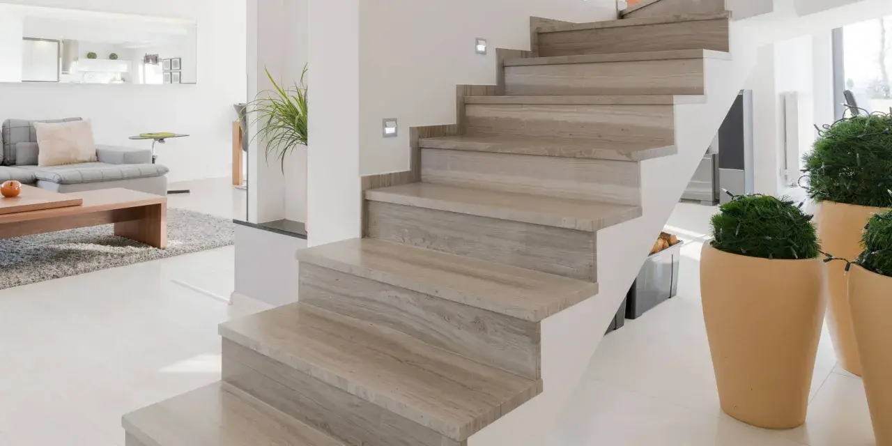 Moderne trap met houten look bekleding, perfect voor trap bekleden ideeen. Sfeervolle verlichting en planten maken het geheel af.