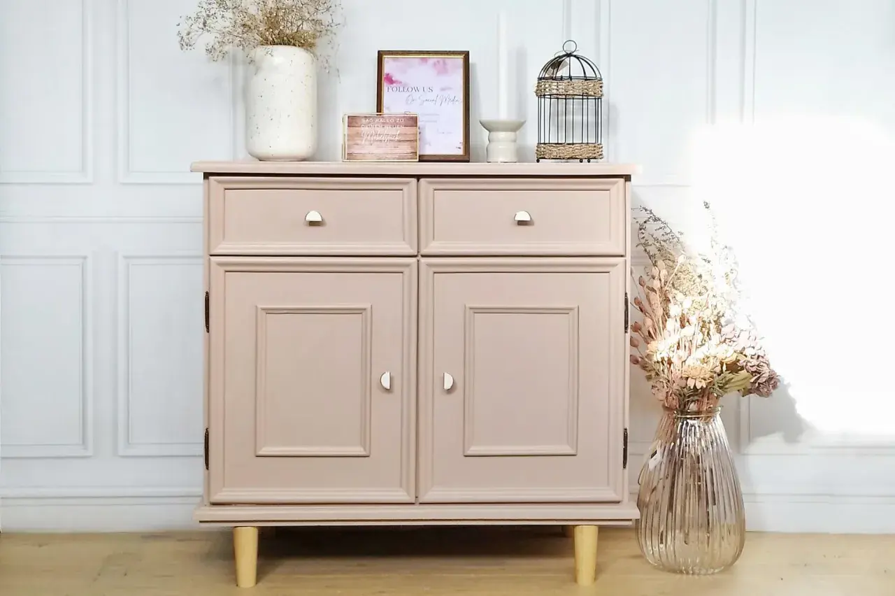 Een **oude kast opknappen voor en na**: deze roze kast is nu een blikvanger met nieuwe pootjes en decoratie.