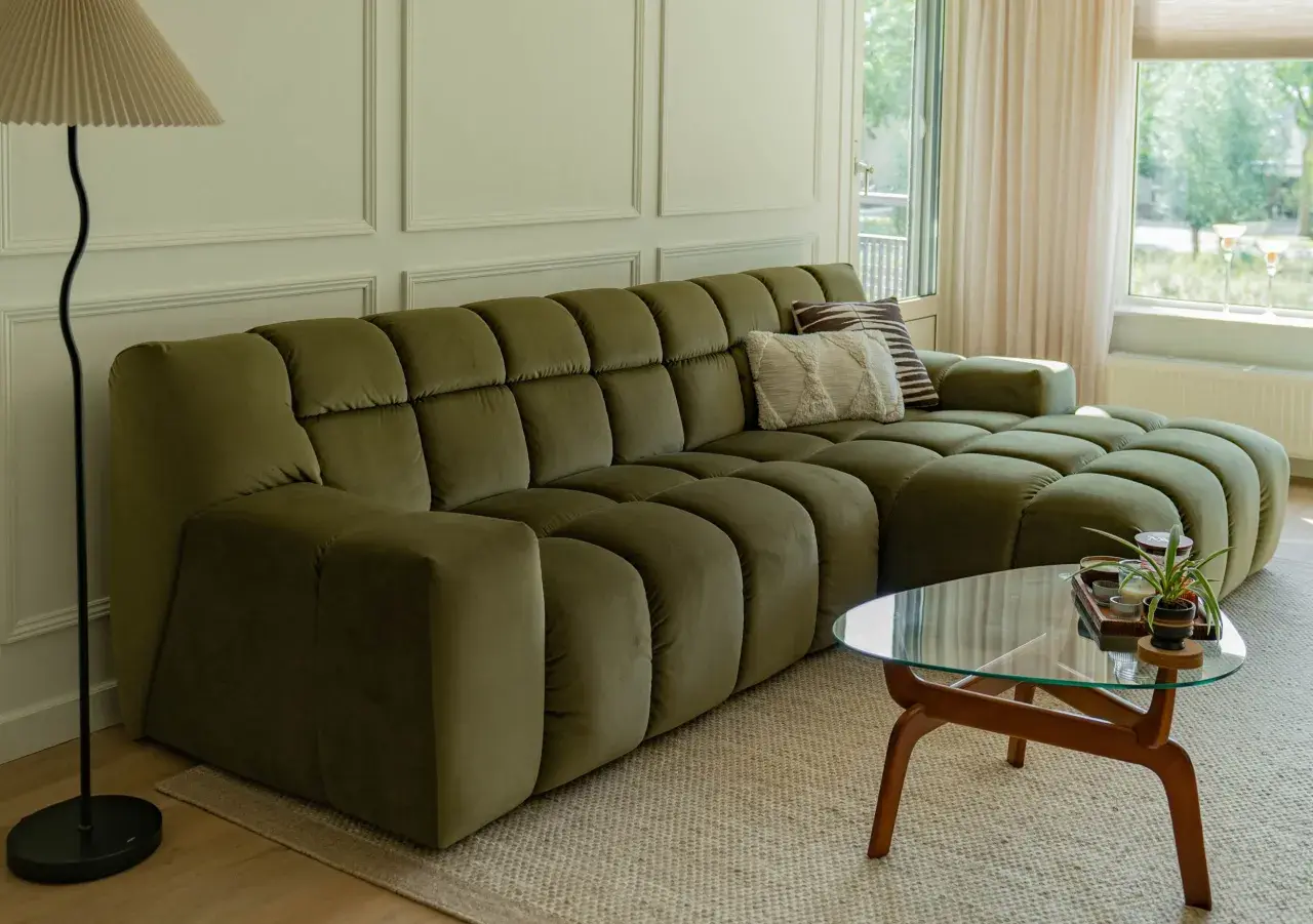 Een olijfgroene bank met zachte kussens, de perfecte basis. Welke kleur past bij groene bank? Denk aan warme aardetinten of frisse pastels voor een harmonieus interieur.