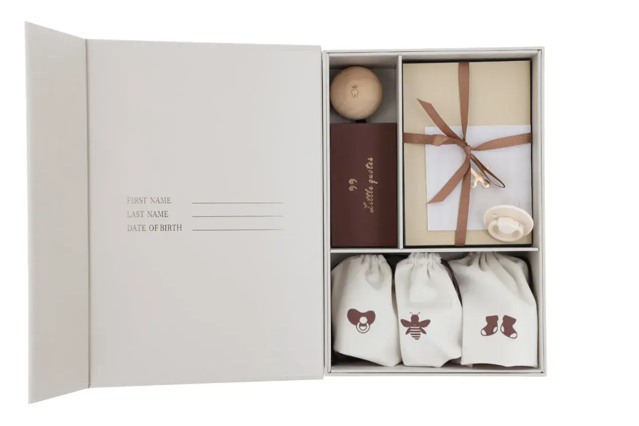 Een mooie set om een memory box te maken met een houten bal, boekje, cadeau en babyartikelen.