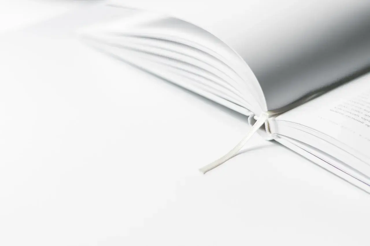 Een open boek met een wit lint, dat de essentie van minimalisme uitstraalt.