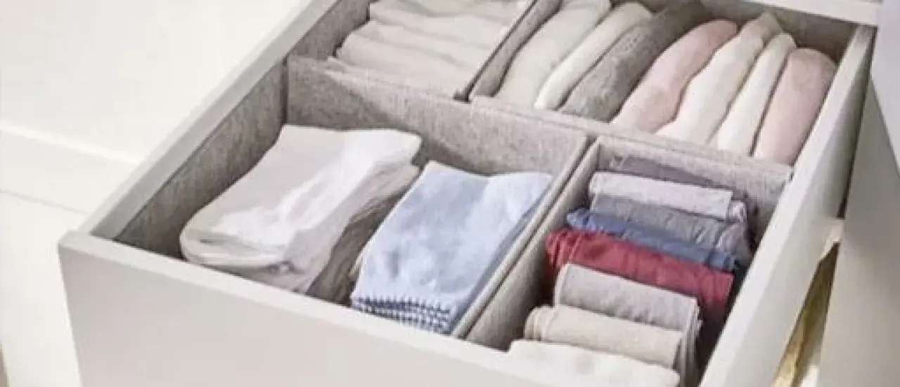 Een opgeruimde lade met netjes gevouwen kleding, geïnspireerd door de Marie Kondo methode. Kledingkast organizers houden alles netjes.